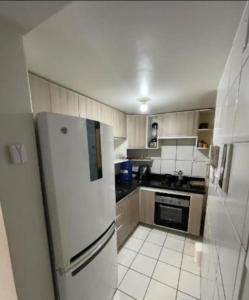 a kitchen with a white refrigerator and a stove at Quarto com ar condicionado tv para uma pessoa in Passo Fundo