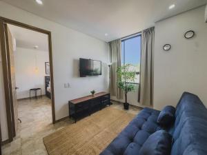 a living room with a blue couch and a television at Fabuloso apartamento en el Mar Caribe - Rodadero in Gaira