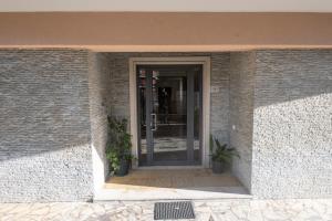 a glass door of a building with two potted plants at 325 - Casa Pede a Deiva Marina - 300metri dalla Spiaggia e dal Mare e dal Centro Storico in Deiva Marina