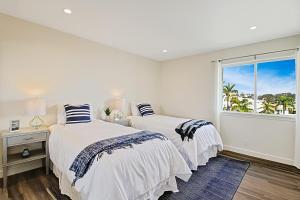 Dos camas en una habitación blanca con ventana. en Leadbetter Beach Retreat, en Santa Bárbara 33 fotos más