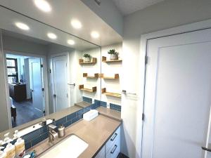 une salle de bain avec un lavabo et un grand miroir dans l'établissement Waikiki Banyan Ohana Suite, à Honolulu 56 autres photos