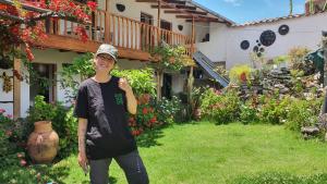 a young man standing in the yard of a house at Casona Mollepata in Mollepata