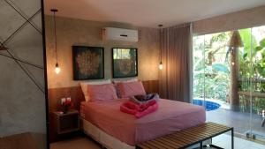 a bedroom with a bed with a pink blanket at Villas Pratagy Flor de Lis 901-Studio in Maceió +15 photos