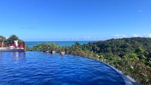 a swimming pool with a view of the ocean at Villas Pratagy Flor de Lis 901-Studio in Maceió