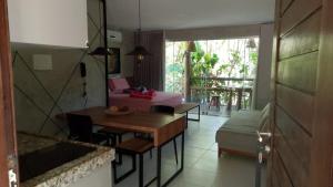 a living room with a table and a bed at Villas Pratagy Flor de Lis 901-Studio in Maceió