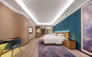 Ένα ή περισσότερα κρεβάτια σε δωμάτιο στο Jiujiang Fanglan Lake Kaiyuan Mingting Hotel