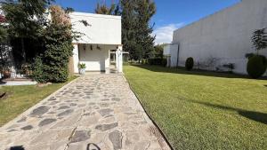 a garden with a stone walkway in front of a building at TX Golf Stay House with XL Jacuzzi and Soccer Field in Tequisquiapan