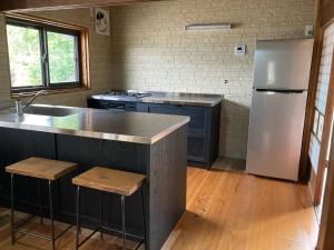 uma cozinha com um frigorífico em aço inoxidável e pisos em madeira em Irori no oyado zen - Vacation STAY 80209v em Mimasaka