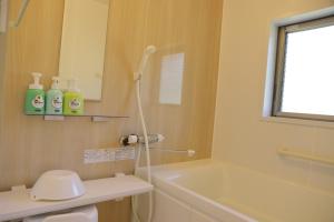 um banheiro com chuveiro, banheira e pia em Irori no oyado zen - Vacation STAY 80209v em Mimasaka