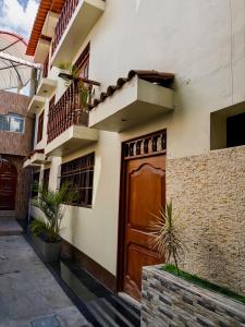 un bâtiment avec une porte en bois et quelques plantes dans l'établissement Castellares la Puebla Hostelería Departamento, à Ayacucho