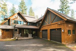 a wooden house with a garage and a driveway at Secluded Golf Course Retreat with Firepit, EV Charging, and Ultimate Privacy in Roslyn
