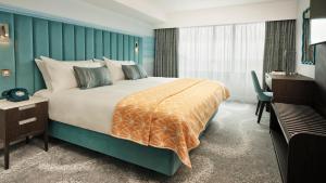 um quarto com uma cama grande e uma escrivaninha em Hotel Indigo Torquay, By IHG em Torquay