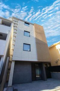 ein Hochhaus mit einem Himmel im Hintergrund in der Unterkunft HOTEL YeeT Tenjin Minami in Fukuoka