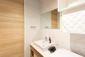 ein Badezimmer mit einem weißen Waschbecken und einem Spiegel in der Unterkunft HOTEL YeeT Tenjin Minami in Fukuoka + 19 Fotos