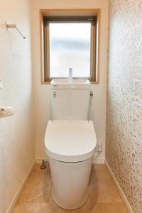 a white toilet in a bathroom with a window at なぎさホテル in Zushi