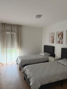 Modern and cozy 2 bedroom fully equipped في أولينز: غرفة نوم بها سريرين ونافذة