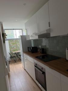 Modern and cozy 2 bedroom fully equipped في أولينز: مطبخ بخزائن بيضاء وطاولة عمل