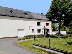 ein weißes Haus mit roten Fenstern und einer Auffahrt in der Unterkunft Eifel Garden Villa for Groups in Karl