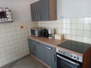 a kitchen with a counter top with a microwave at Eifel Garden Villa for Groups in Karl