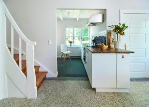 une cuisine avec des placards blancs et un escalier dans l'établissement Charming Flat In Historic Country House, à Meezen 13 autres photos