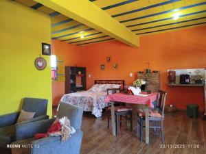 a bedroom with a bed and a table and chairs at Chalé Catarina Mendes in Ouro Preto