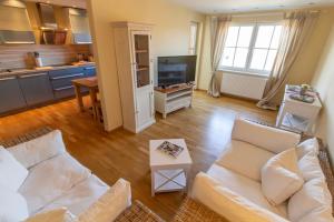 a living room with a white couch and a kitchen at Ferienwohnung Villa Albatros In Oberdellach in Ober-Dellach