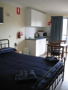 ein Schlafzimmer mit einem großen Bett und eine Küche in der Unterkunft Delegate Studio Cabin in Delegate
