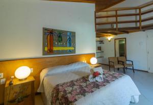 a bedroom with a bed with two lamps on it at Hotel Karapitangui in Morro de São Paulo
