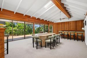 Noosa Retreat. Ocean Views, Pool and Serenity في نوسا هيدز: غرفة طعام بها طاولة وكراسي