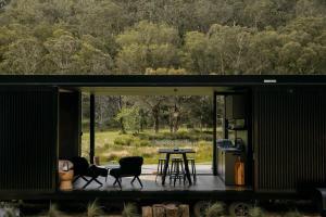 a small black house with a table and chairs at The Lookout - a Huch experience in Wollombi