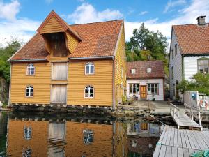a house sitting on the water in front of a house at Rugsund Handelsstad in Rugsund