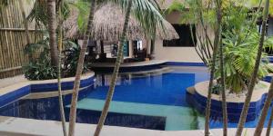 a pool with palm trees in a hotel at birdwatchers beachfront hotel panglao in Panglao Island