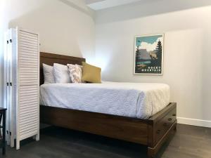 ein Schlafzimmer mit einem Bett und einem Bild an der Wand in der Unterkunft Steps to Lake Fireplace Indoor Outdoor Oasis in Grand Lake