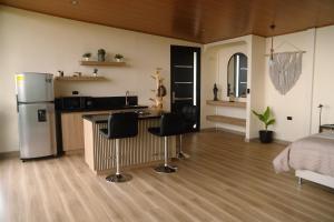 a kitchen and living room with a bed and a refrigerator at Cabaña Amanecer in Pereira +10 photos