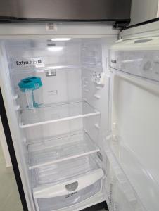 un frigorifero vuoto con la porta aperta in una cucina di acogedor Apartamento en el centro de Cali, cerca a todo a Cali Altre 17 foto