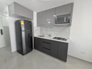 una cucina con frigorifero in acciaio inox e forno a microonde di acogedor Apartamento en el centro de Cali, cerca a todo a Cali
