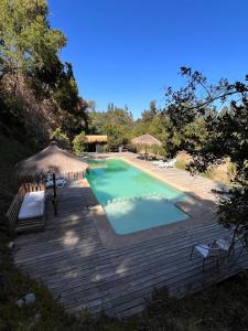 una piscina con sombrilla y una terraza de madera en House in the Maule River Bay, en Constitución
