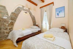 a bedroom with two beds and a stone wall at Holiday home in Marusici - Istrien 39238 in Grižane +48 photos