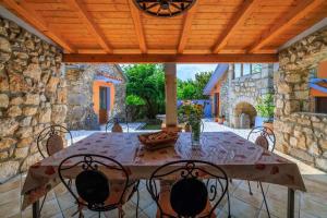 a patio with a table and chairs under a wooden ceiling at Holiday home in Marusici - Istrien 39238 in Grižane