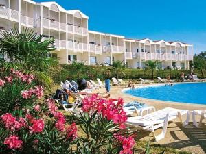 un complexe avec une piscine, des chaises et des fleurs dans l'établissement Appartement 4 personnes, rez-de-chaussée, piscine, plage à 200 m, wifi - FR-1-709-32, à Fouras