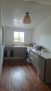 a kitchen with a sink and a washing machine at La Case in Rémiré +9 photos