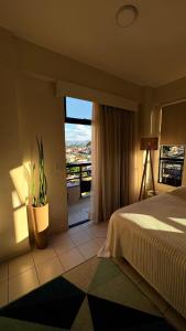 Un dormitorio con una cama y una ventana grande en Studio Caxambu MG, en Caxambu