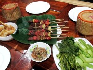 a table with plates of food on a green leaf at Nicolas Homestay Mekong Home in Pakse