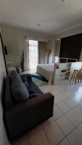 una sala de estar con un sofá y una cama en Studio Caxambu MG, en Caxambu 17 fotos más