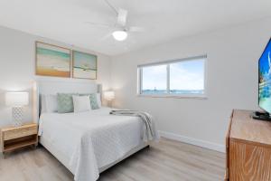 Una habitación blanca con una cama y una ventana en Cocoa Beach Towers, en Cocoa Beach