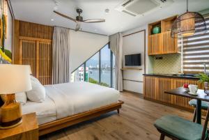 um quarto com uma grande cama branca e uma cozinha em Riverside Seahorse Danang Hotel em Da Nang