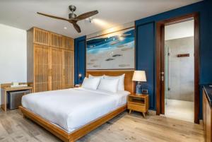 a bedroom with a large white bed and a blue wall at Riverside Seahorse Danang Hotel in Da Nang