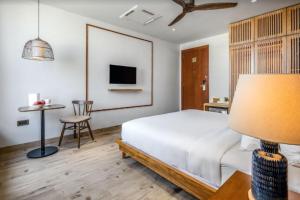 um quarto com uma cama e uma mesa com uma cadeira em Riverside Seahorse Danang Hotel em Da Nang mais 14 fotografias