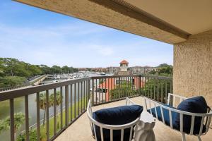 a balcony with two chairs and a view of a city at 236 Captains Quarters in Hilton Head Island