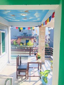 Un patio con una mesa y sillas en un balcón. en Pokhara Apartment CS, en Pokhara